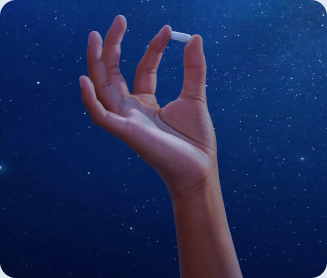 Hand holding a Stasis Kids gummy against a starry night sky